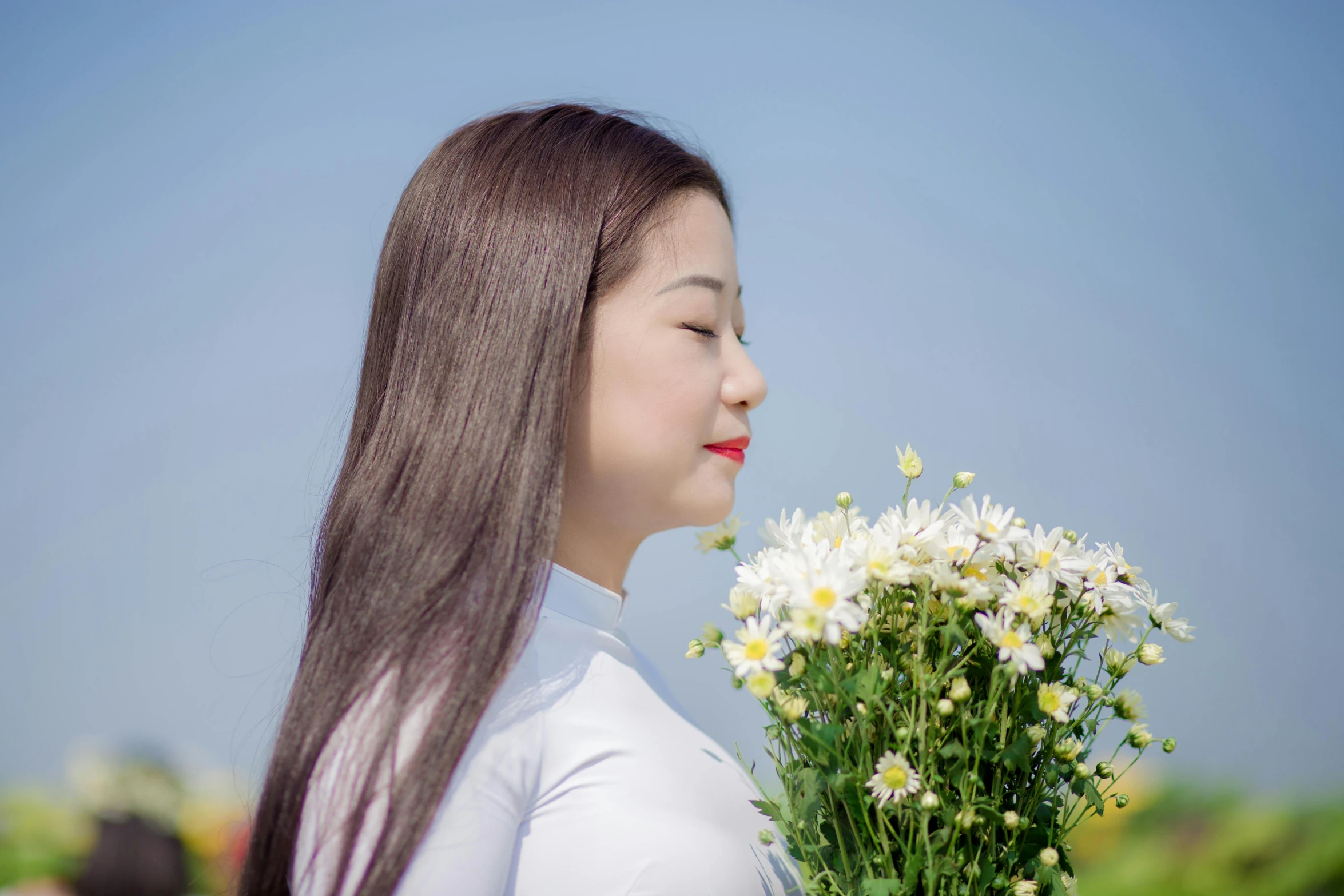 a woman that is standing in front of some flowers