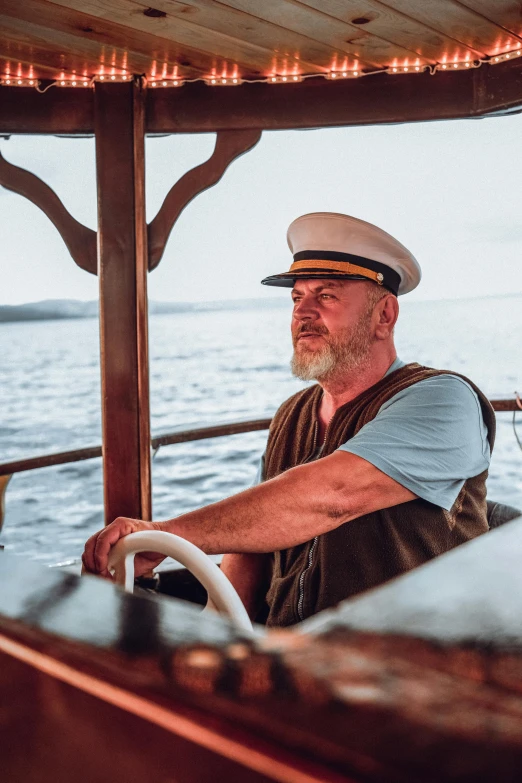 a man sitting on top of a boat in the water