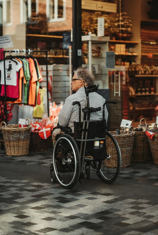 an old man sitting on a wheelchair looking away from the camera