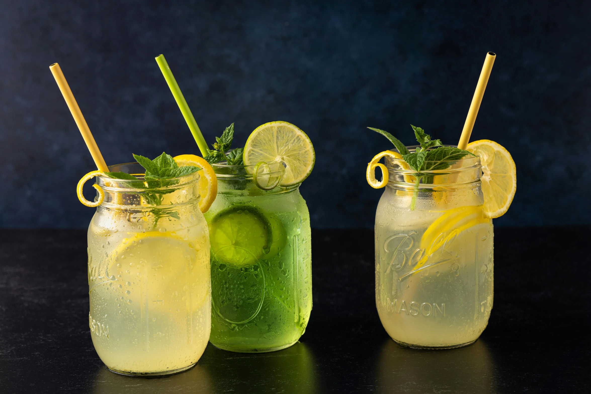 two glasses with lemon and mojita drinks