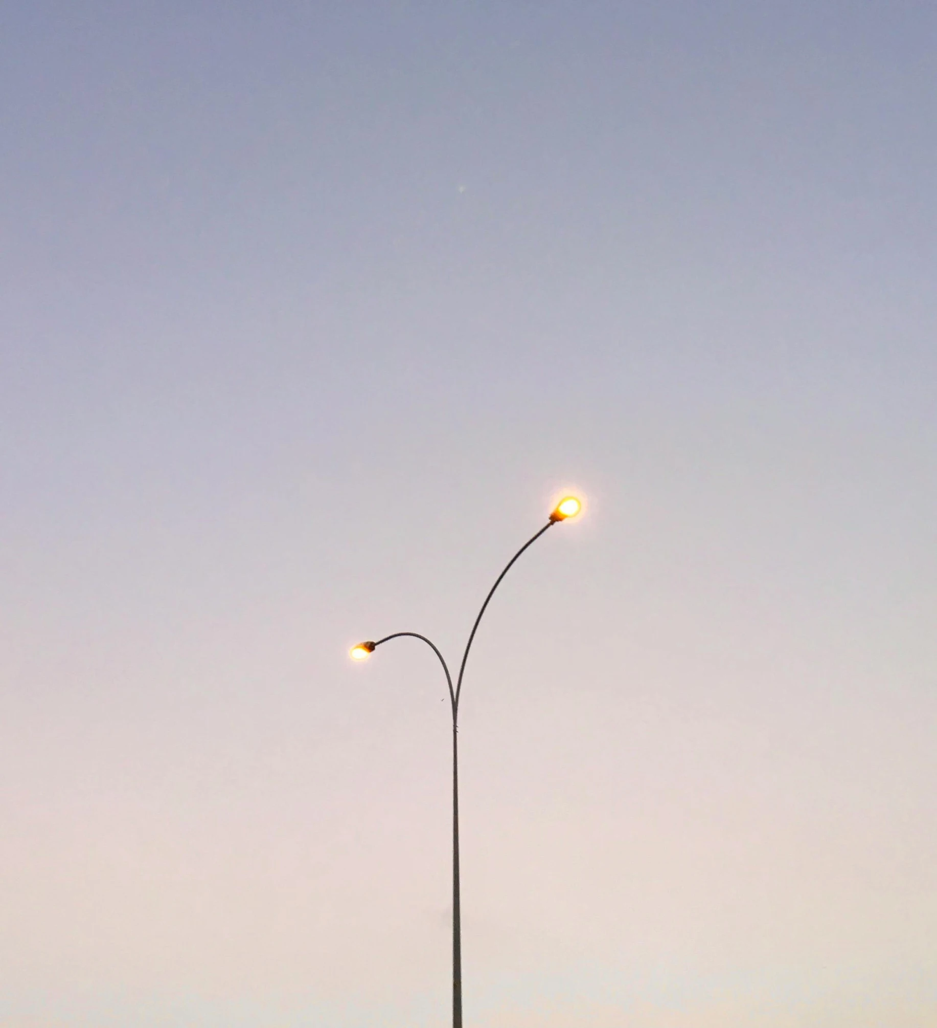 two light post with an almost empty street below