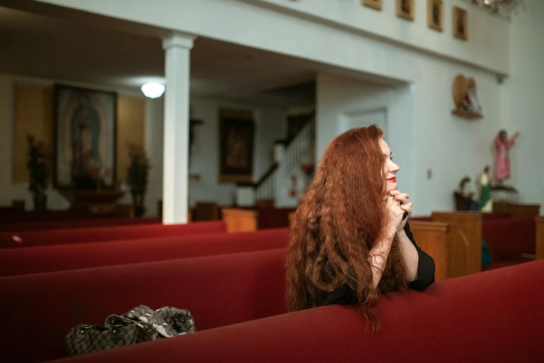 a woman with long red hair in an auditorium