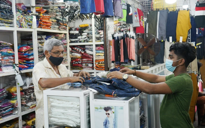 an older man and a woman are shopping for clothing