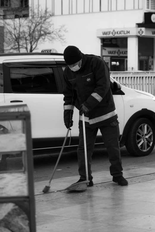 a person in a black and white po cleaning sidewalk