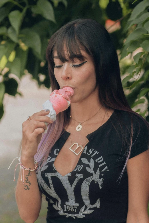 a young woman holding a donut while eating it