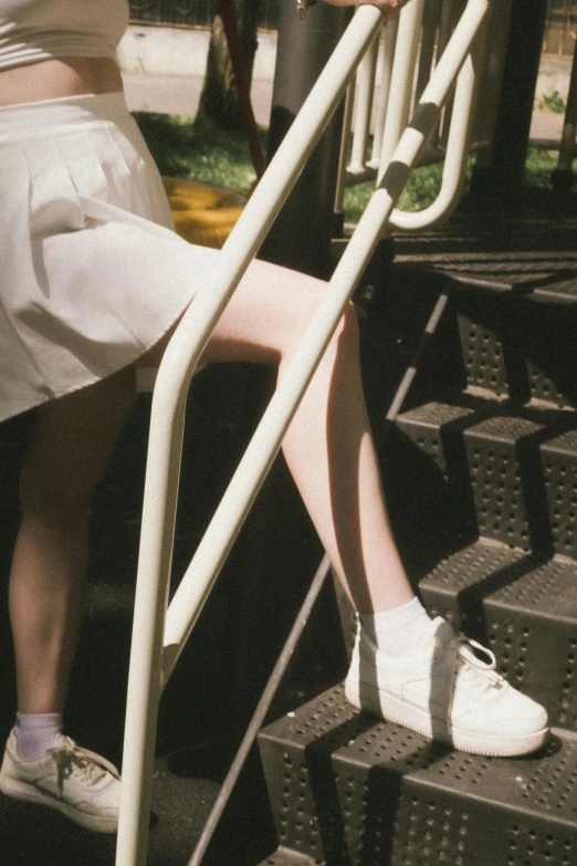 a woman sitting on a step next to an iron railing
