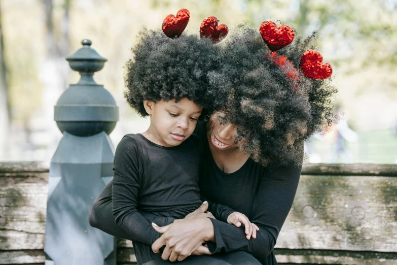 mother and son hugging while holding curly hair