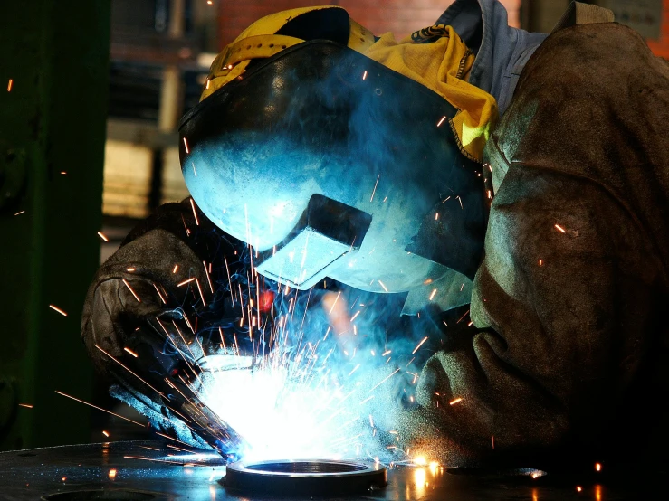 the man is welding on the steel outside