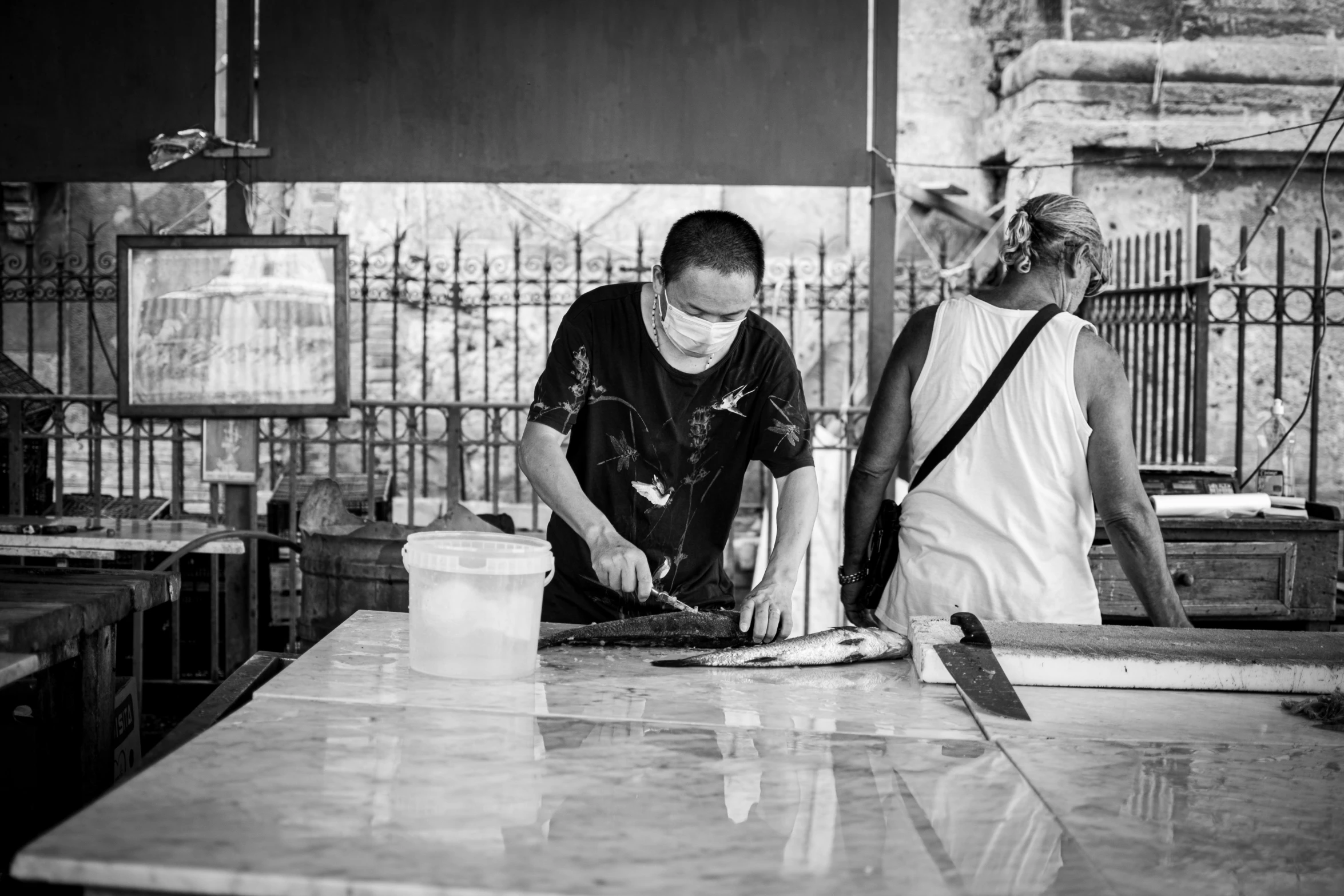 a man and woman preparing food in a kitchen