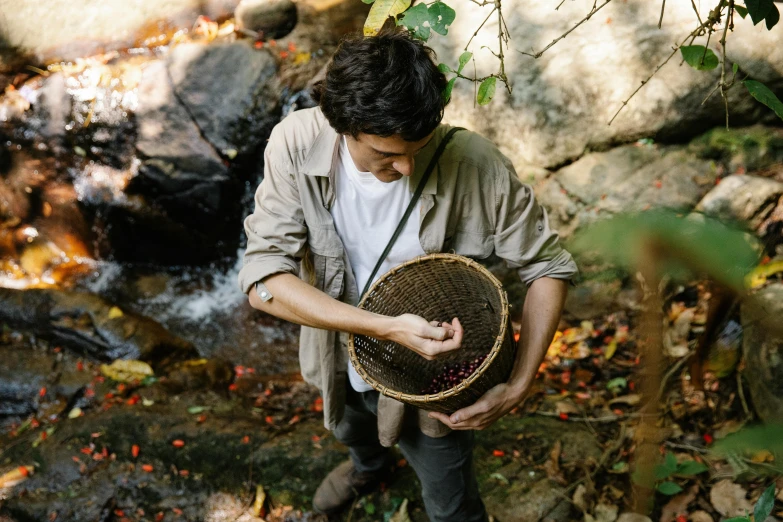 man in a white shirt holding a brown hat