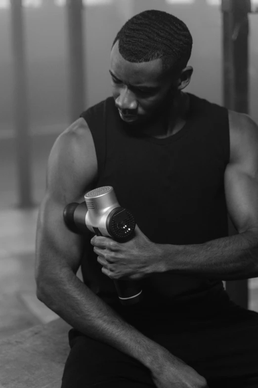 black and white po of a man in a gym setting holding an object