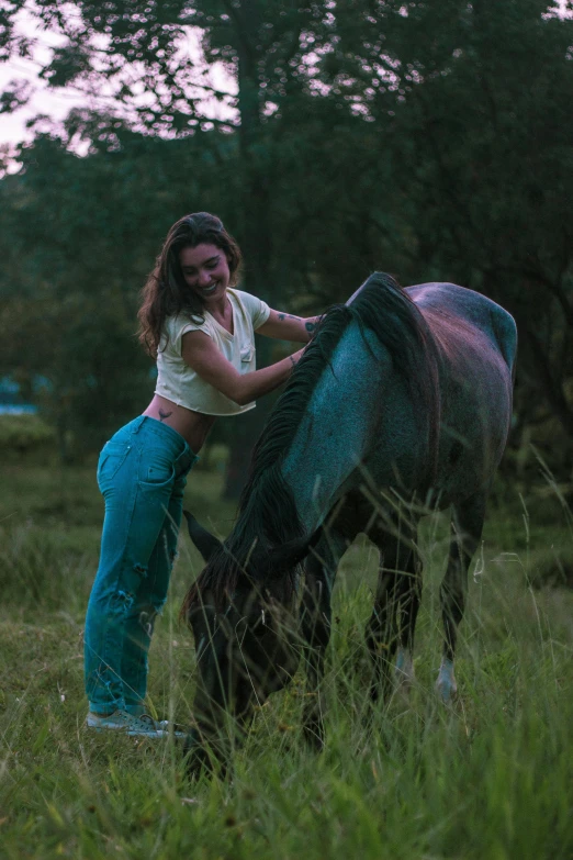 there is a woman standing next to a brown horse