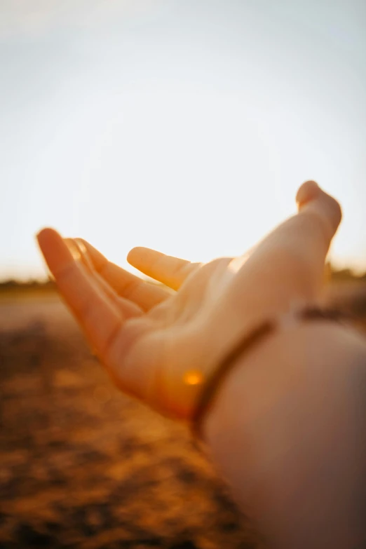 a person's hand in the desert on the ground