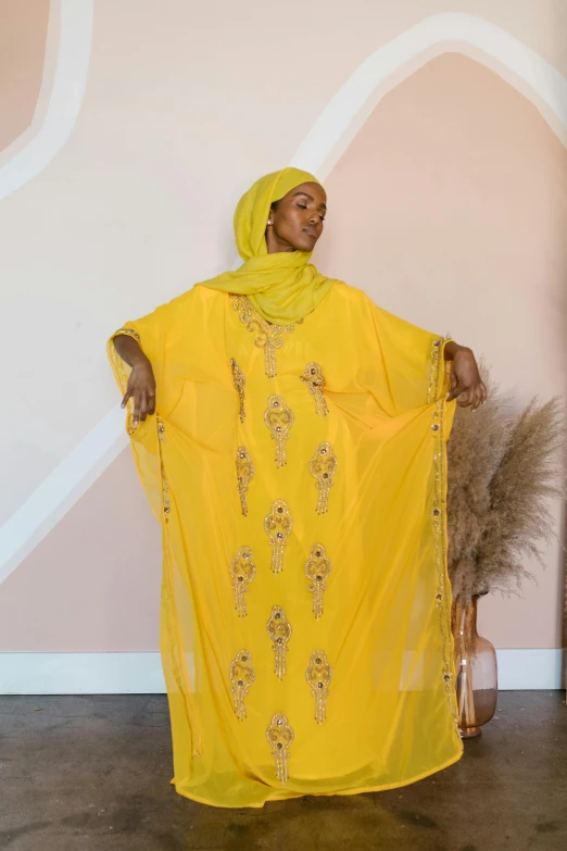 a woman in yellow sitting on top of a brown chair