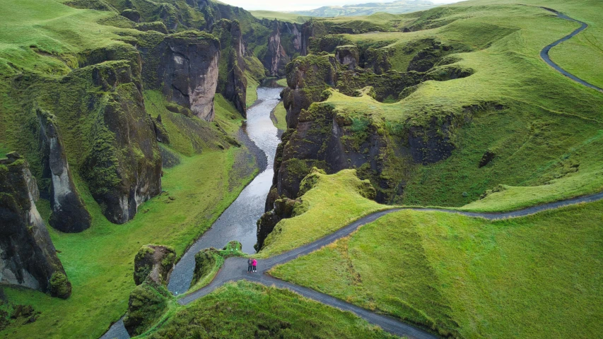 an aerial view of a river flowing through a grassy valley