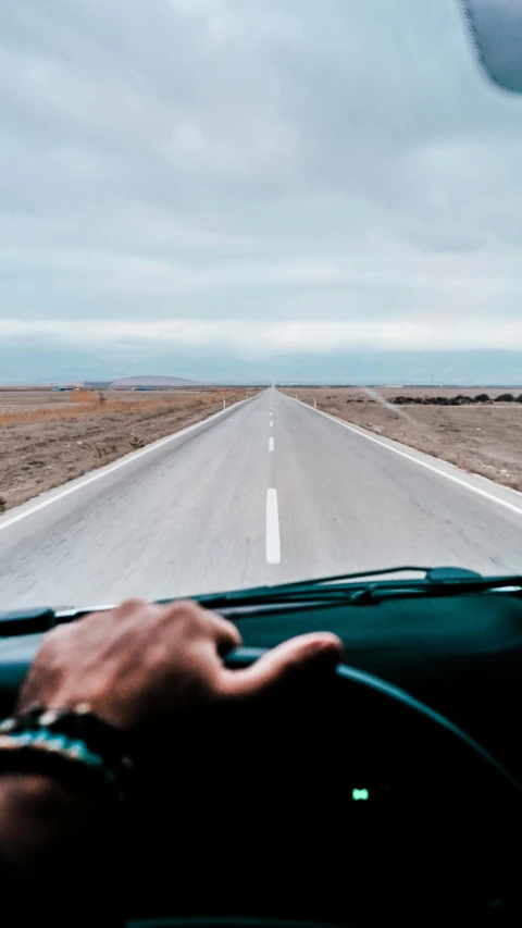 the inside of a car driving on a desert road