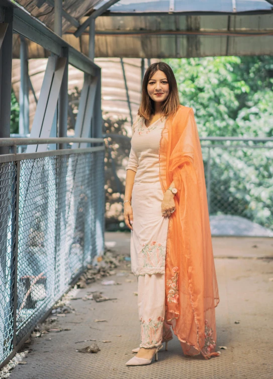 a woman wearing a long white and orange outfit