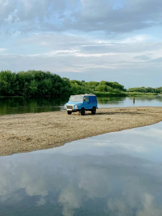 a van parked at the edge of a body of water