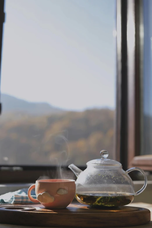 tea pot and tea cups with mountain view from table