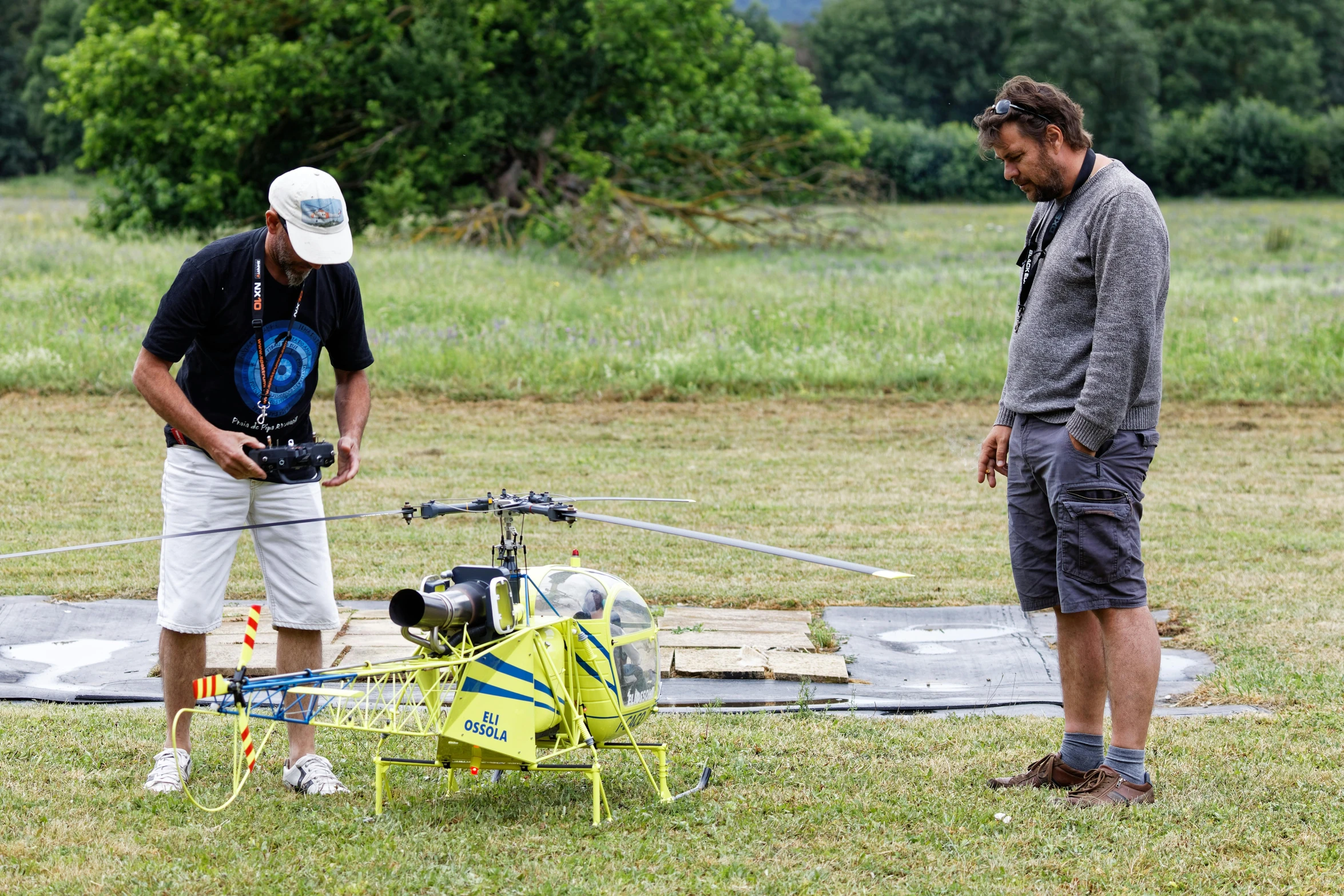 two people near a helicopter on a field