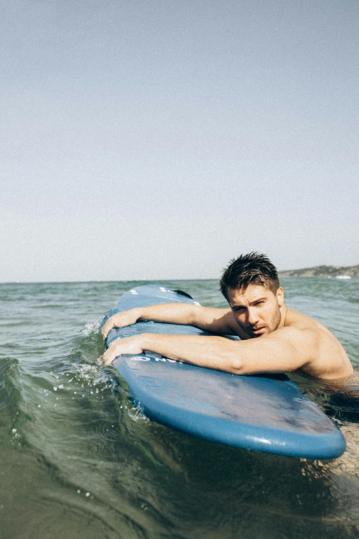 the surfer has one arm on his board