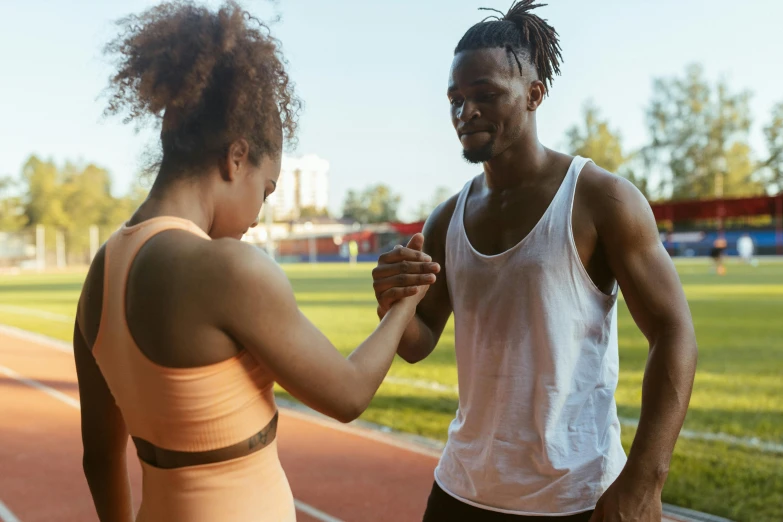 man and woman preparing to start a run on track