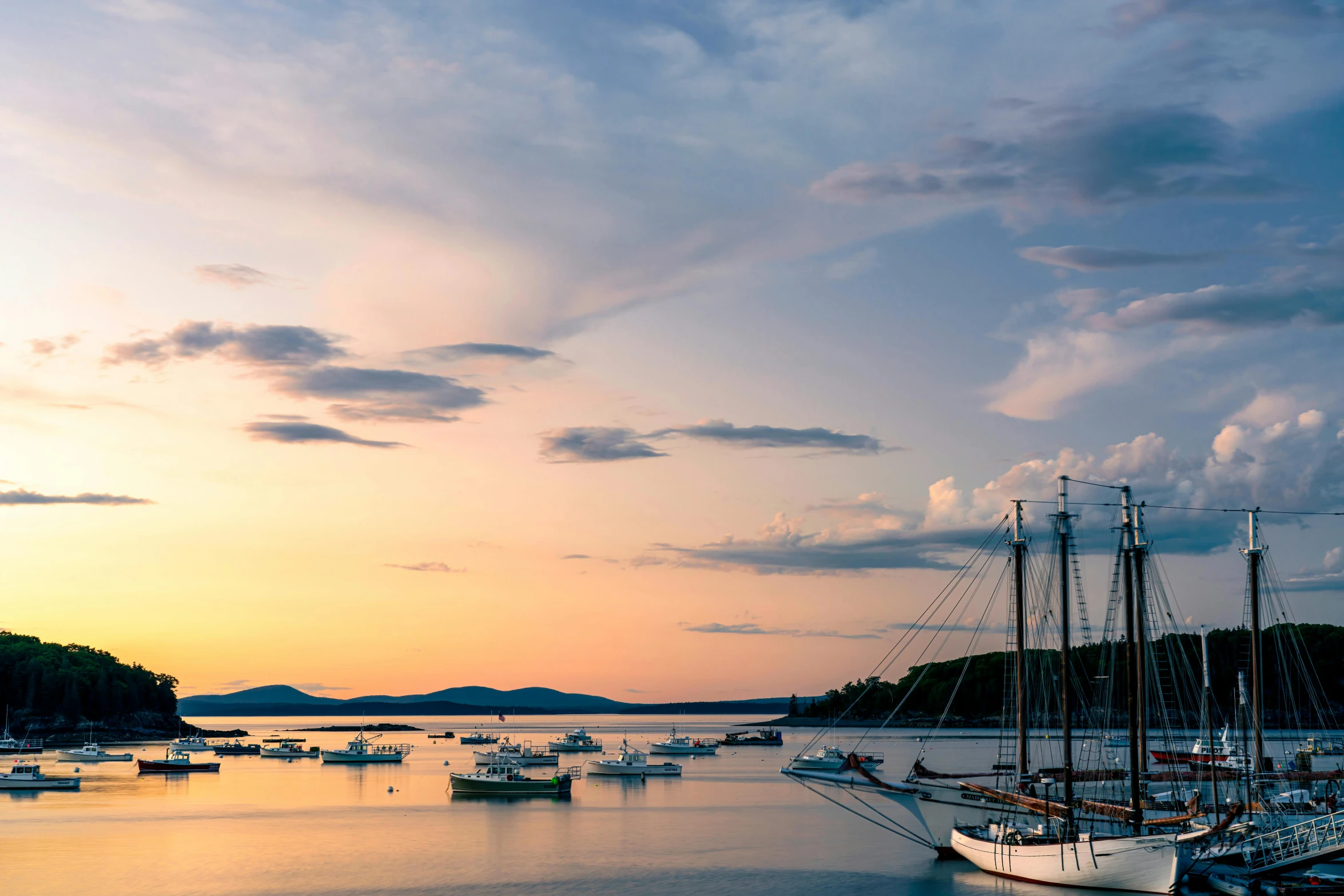 many boats are docked in the water during the sunset