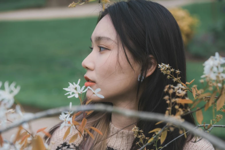 a person with very long hair is standing near flowers