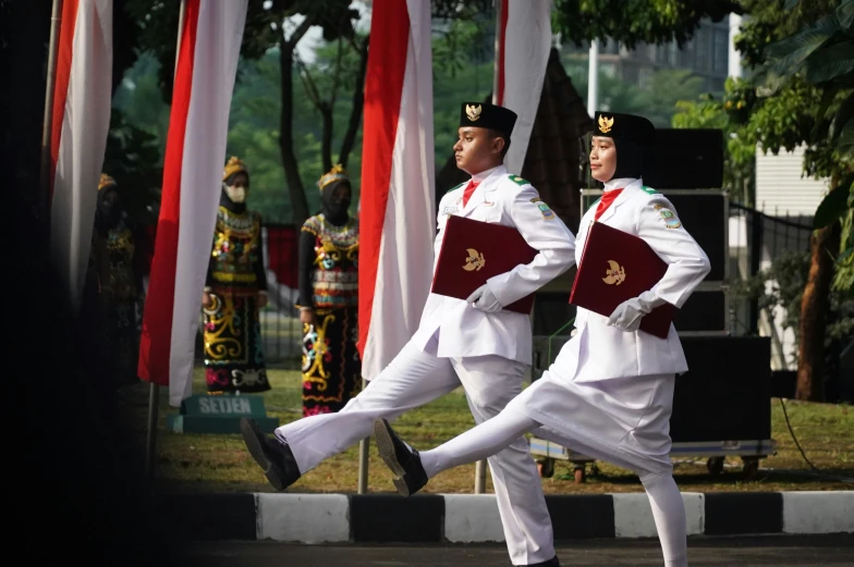 two men are dancing in formal attire at an outdoor event