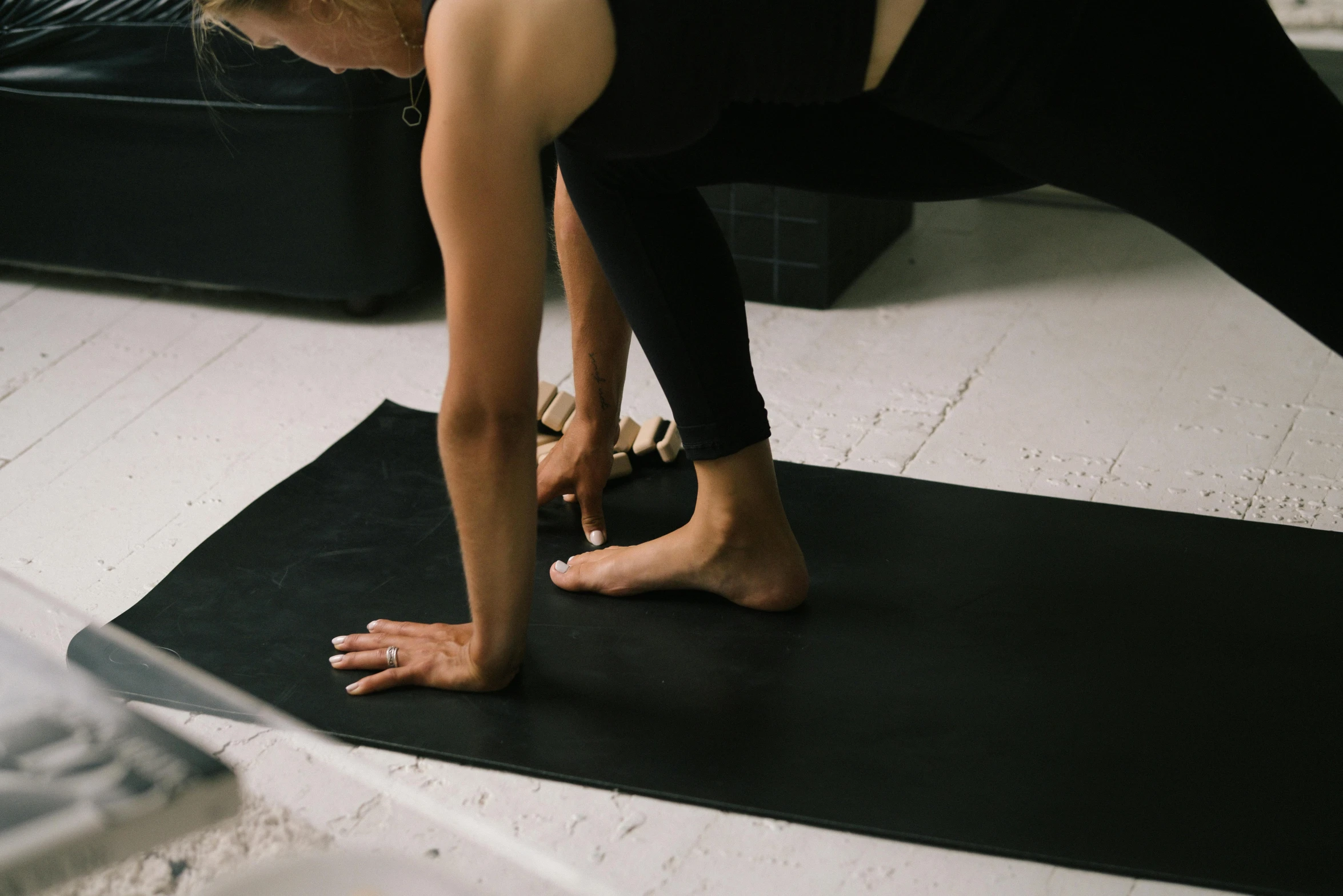 a woman stretches out on a mat with her feet propped up