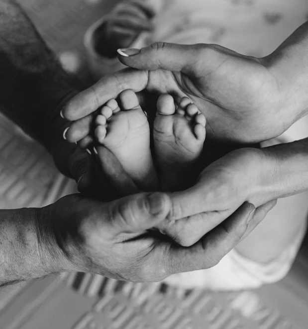 an infant feet in the palm of its mothers hands