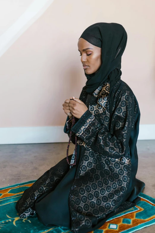 a woman sits on a rug knitting