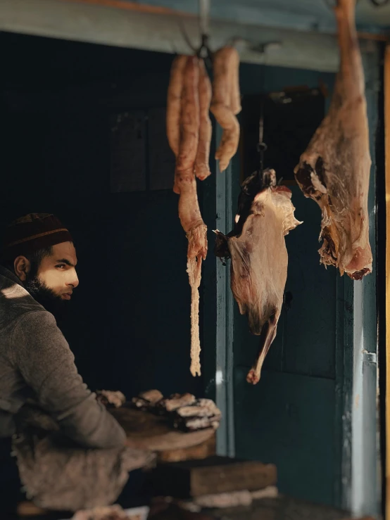 a man is  and drying meat on a hook