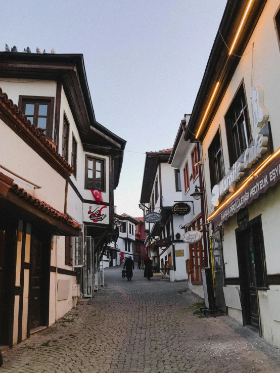 a narrow street with several white buildings next to each other