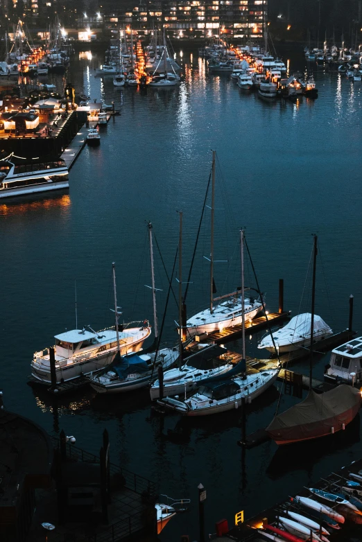 several boats are parked at a dock at night