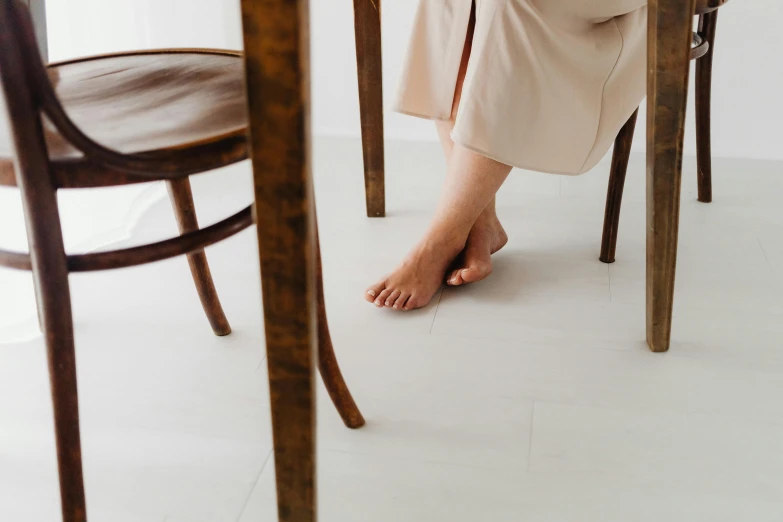 a woman sitting at a table that has been made from wooden furniture