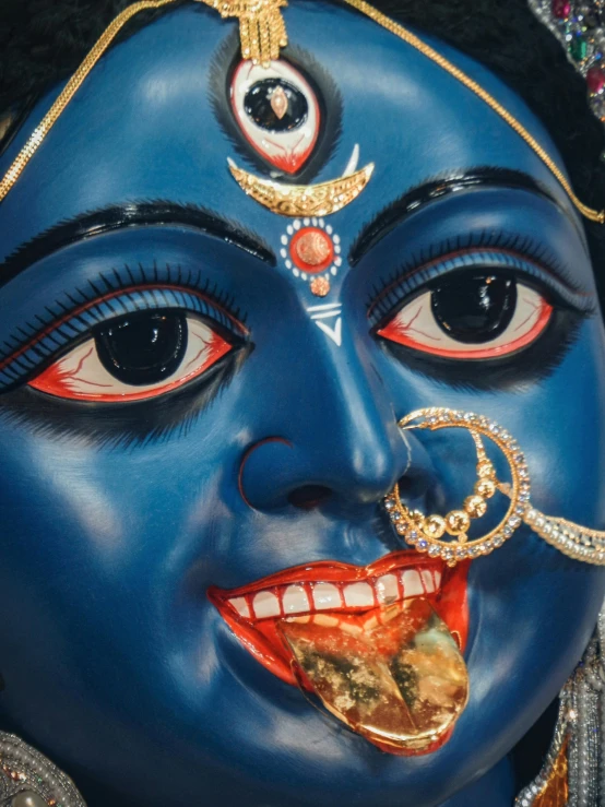 blue face painted with gold and red designs