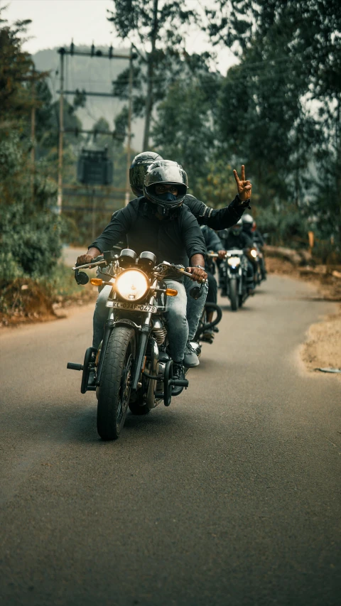 men on motorcycles traveling down a long road