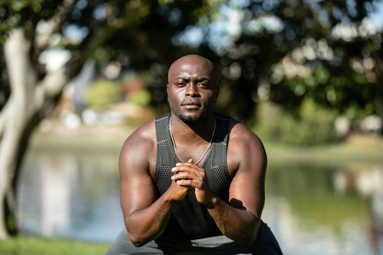 a man sitting in front of a pond