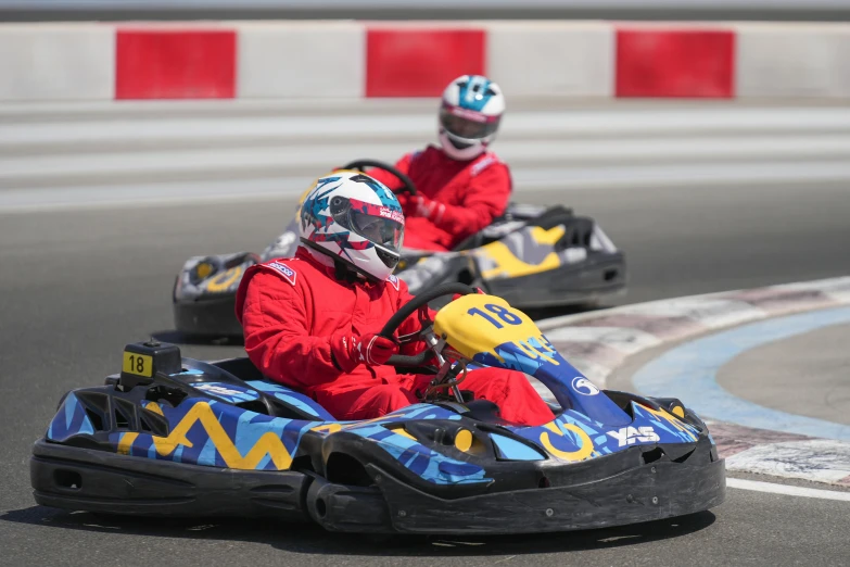 two s race down the track on go carts