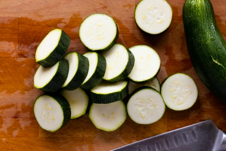 zucchini and slice on a wooden surface with knife