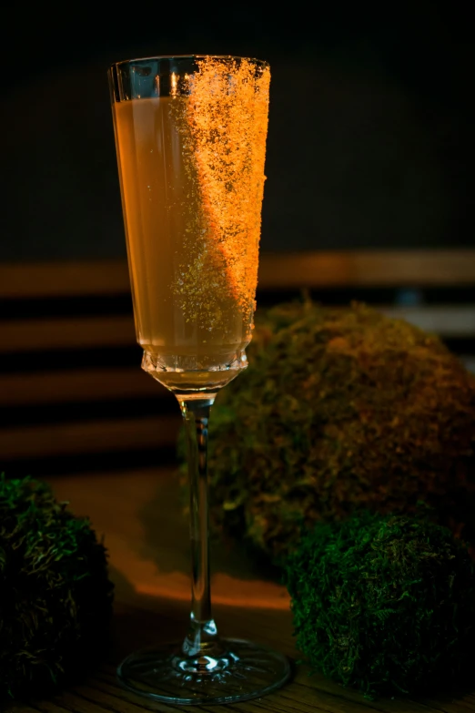 a drink in a wine glass sitting on top of a table