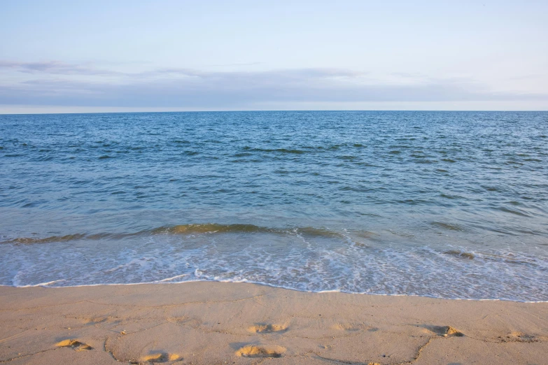 a blue sky and water next to the beach