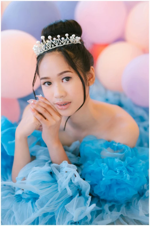 a little girl in a tutu laying on a couch wearing a tiara