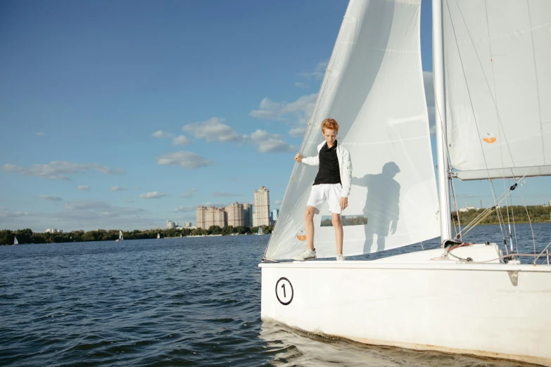 a man standing on the side of a sail boat