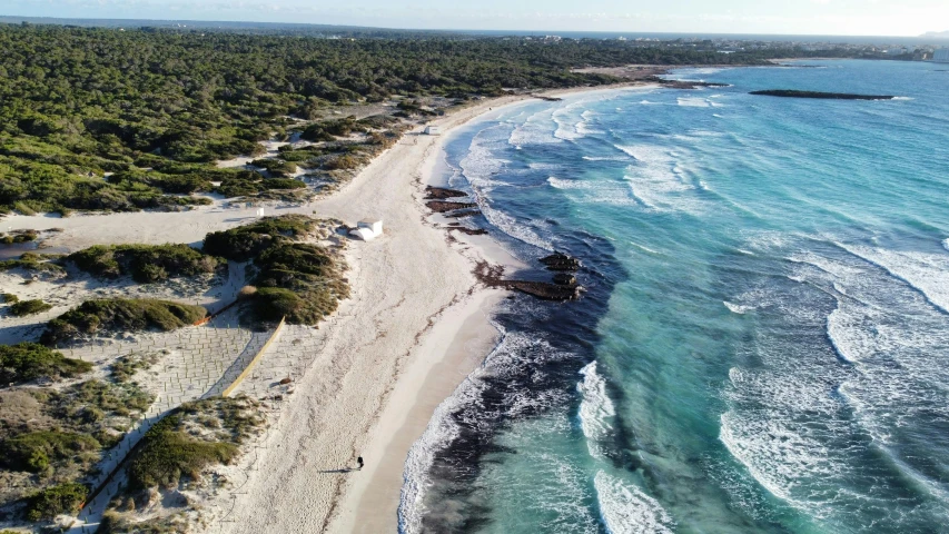 an aerial view of a sandy beach next to the ocean