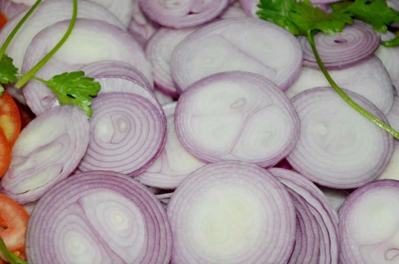 a pile of red onions and carrots laying on top of each other