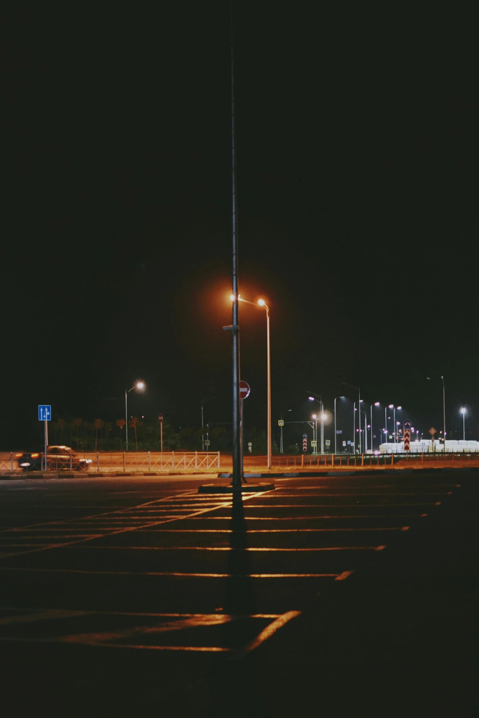 an empty parking lot at night with a light pole