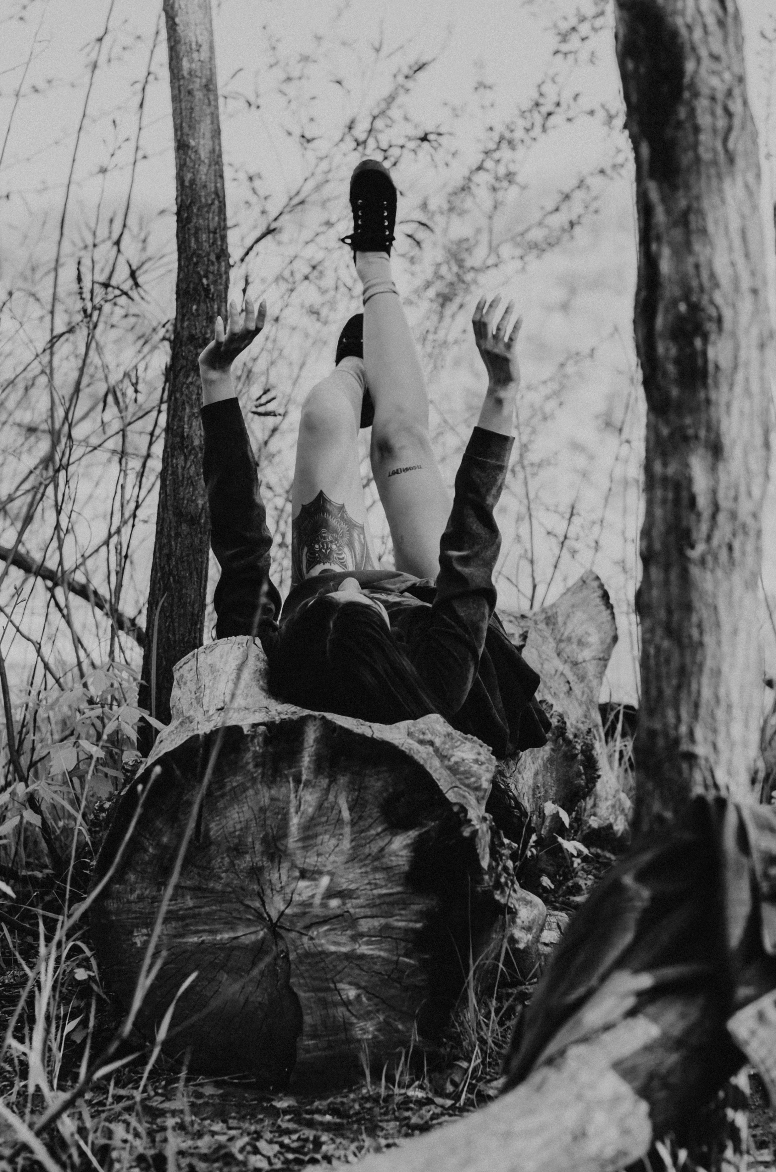 black and white po of a man lying on the ground on a rock