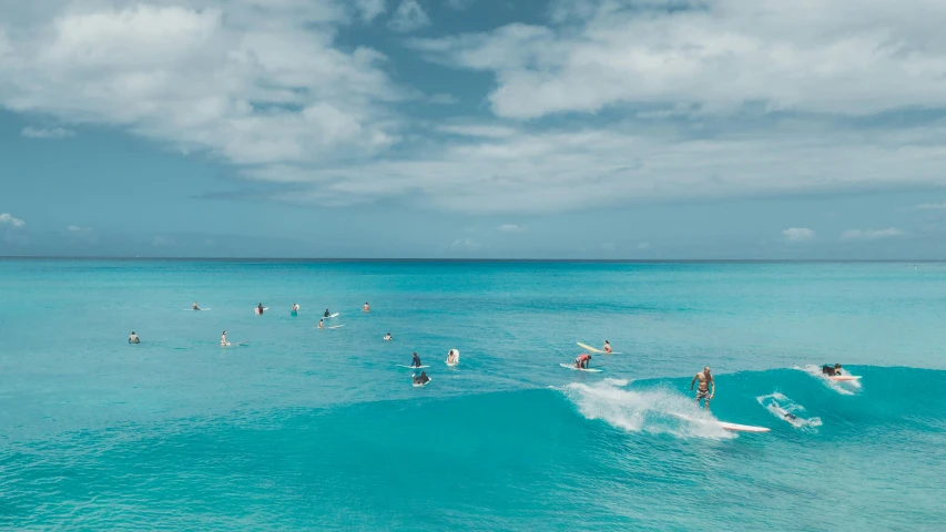 a number of people on surf boards riding the same wave